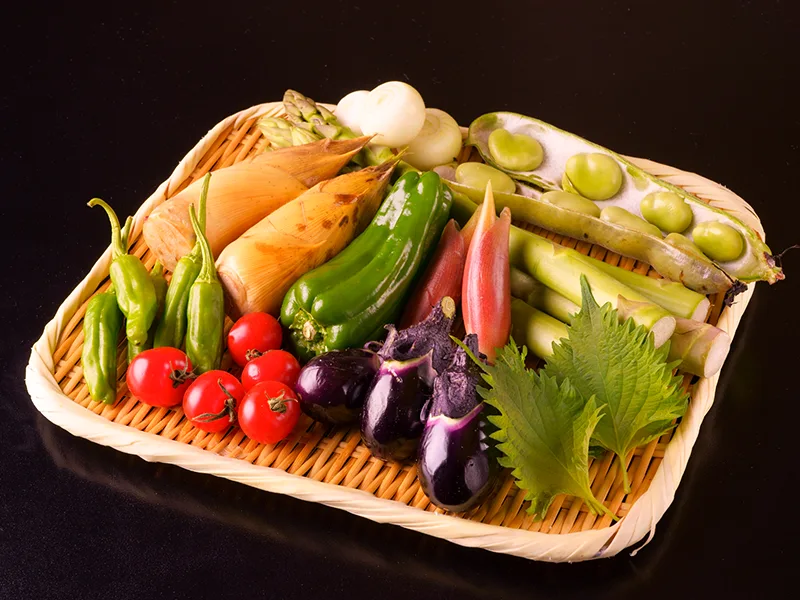 竹ざるに盛られた季節の野菜。筍、そら豆、みょうが、アスパラ